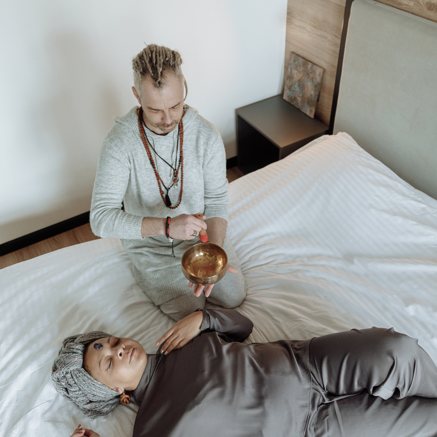 a man holding a bowl over a woman lying on a bed. How to meditate in bed