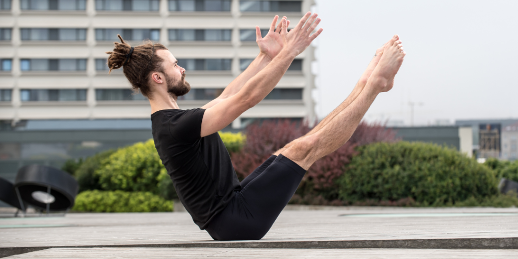 Benefits of Yoga for men. A man doing boat pose