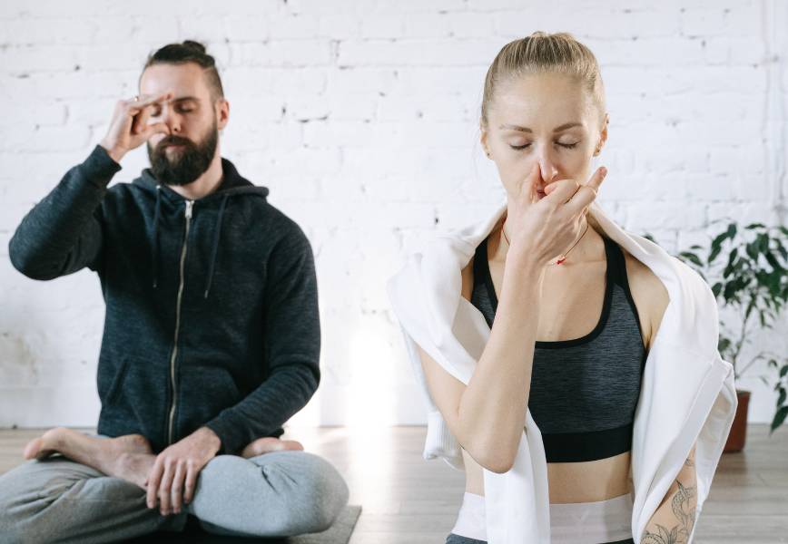 a man and woman sitting on yoga mats - Breathing techniques in Meditation