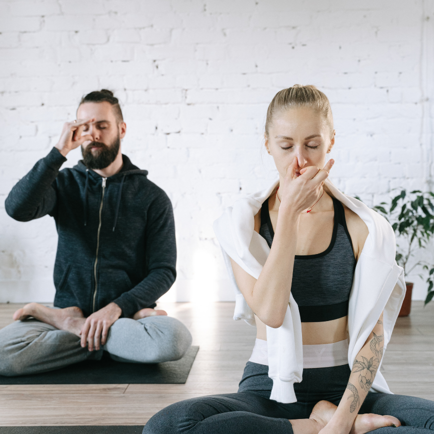 a man and woman sitting on yoga mats - Breathing techniques in Meditation